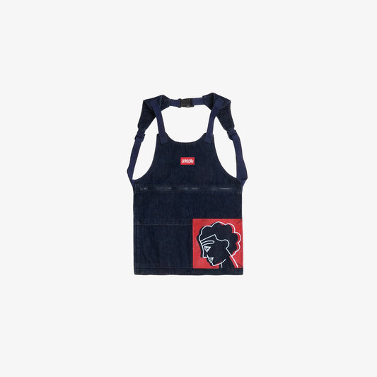 Pièce hybride entre le sac et l’utilitaire, cet accessoire s’inspire du tablier professionnel pour allier fonctionnalité et design. Équipé de trois poches, il mise sur un équilibre entre praticité et esthétique. Une sérigraphie est placée sur la poche droite au porté, reprenant les aplats rouges et lignes blanches de la fresque Avec Vous. Confectionné en denim deep indigo rinse 100% coton, avec surpiqûres ton sur ton, bouton embossé et gomme personnalisée.