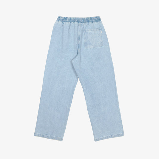 Palazzo confort (jambe large) avec dessin au laser en plein sur le devant et la poche plaquée dos, droite au porté. Taille élastiquée. Denim bleached, 100% coton. Surpiqûres gros fil ton sur ton.
