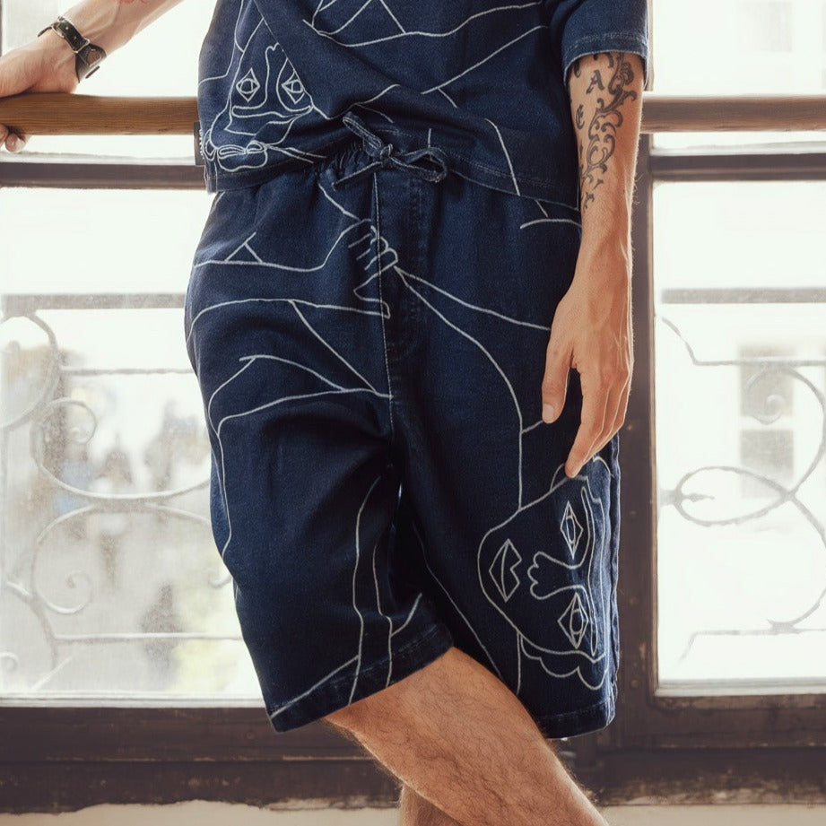 Short palazzo confort (jambe large) avec dessin au laser au trait sur le devant et la poche plaquée dos, droite au porté. Taille élastiquée. Maille indigo 83%coton-15%plolyester-2%elastane. Surpiqûres gros fil ton sur ton.