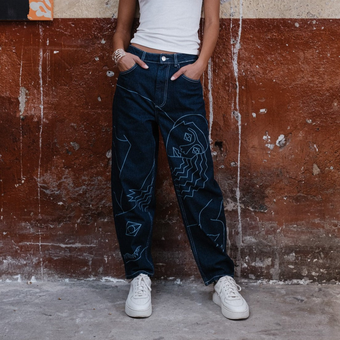 vêtement original de créateur. Dessin au trait imprimé au laser placé sur le devant du pantalon.
À poser sur la taille ou descendu sur les hanches pour accentuer le style loose du modèle.
Base tissu : denim deep indigo rinse 100% coton. Surpiqûres contrastées blanc optique. Bouton et Jacron cuir embossé personnalisés Chazeau.