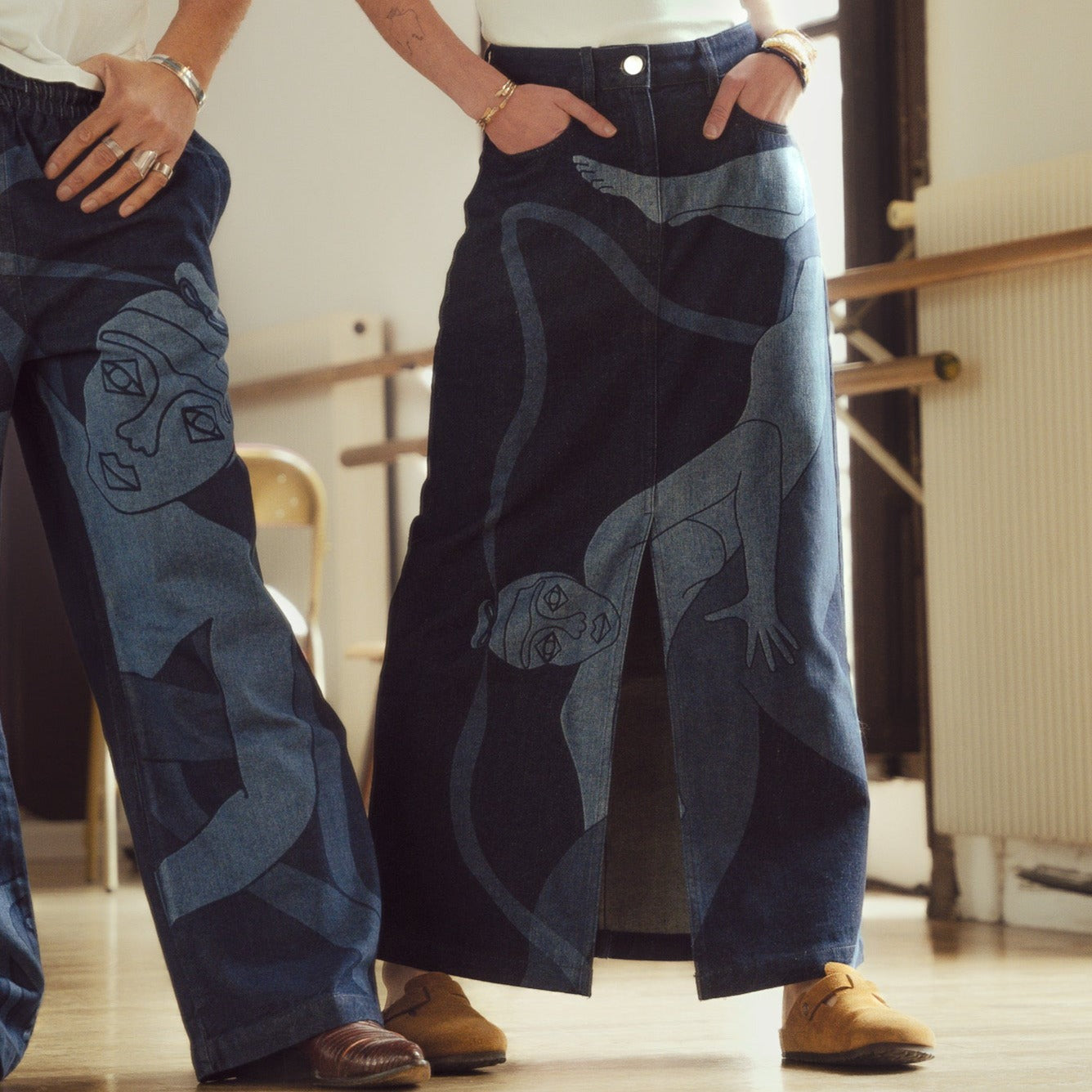 Jupe longue en jeans avec dessin au laser en plein sur le devant et la poche plaquée dos, droite au porté. Denim deep indigo rinse, 100% coton. Surpiqûres gros fil ton sur ton. Bouton et jacron cuir embossés, personnalisés.