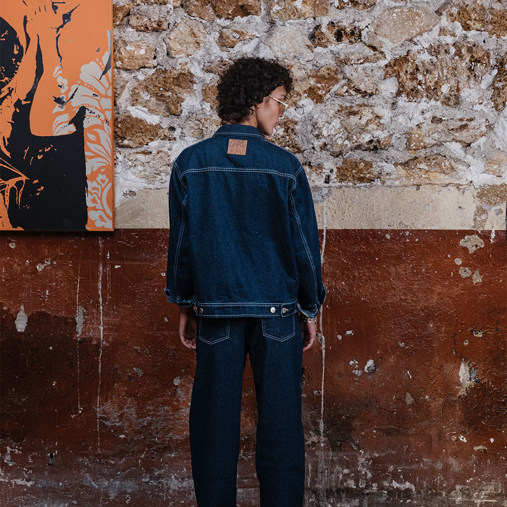 vêtement original de créateur. Dessin au trait imprimé au laser placé sur le devant du pantalon.
À poser sur la taille ou descendu sur les hanches pour accentuer le style loose du modèle.
Base tissu : denim deep indigo rinse 100% coton. Surpiqûres contrastées blanc optique. Bouton et Jacron cuir embossé personnalisés Chazeau.