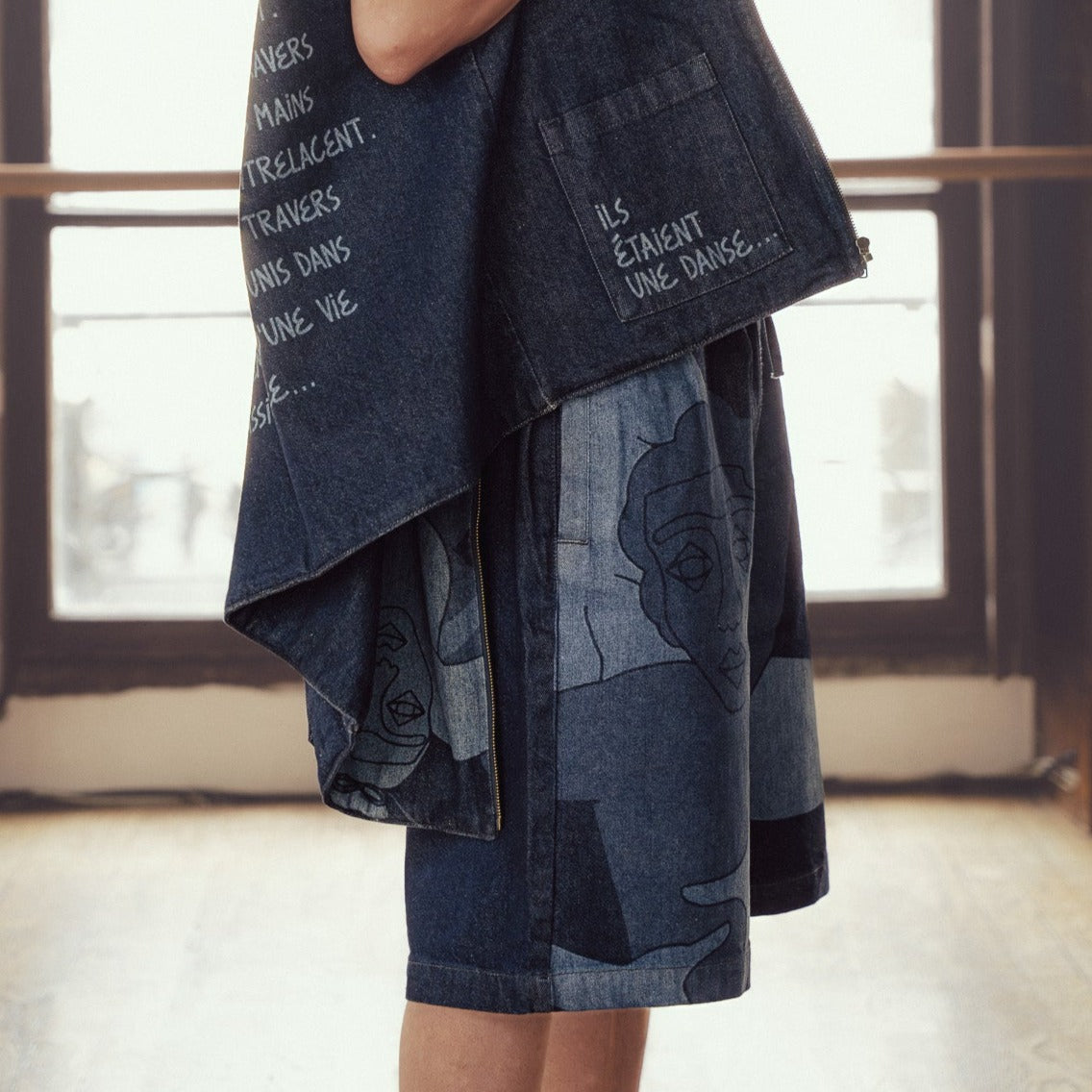 Short large avec dessin au laser en plein sur le devant et la poche plaquée dos, droite au porté. Taille élastiquée. Denim deep indigo rinse, 100% coton. Surpiqûres gros fil ton sur ton.