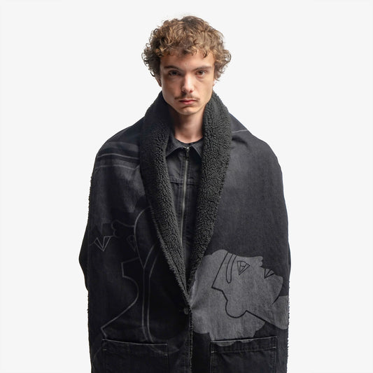 Grande écharpe noire en denim 100% coton, dotée d’un bouton permettant un porté poncho. Son volume généreux offre chaleur et confort, tandis que son design versatile permet de multiples styles de portés. Une impression laser couvre toute la surface, en hommage à la fresque Avec Vous. Surpiqûres contrastées grises, bouton et jacron en cuir teinté noir viennent parfaire son allure sophistiquée.