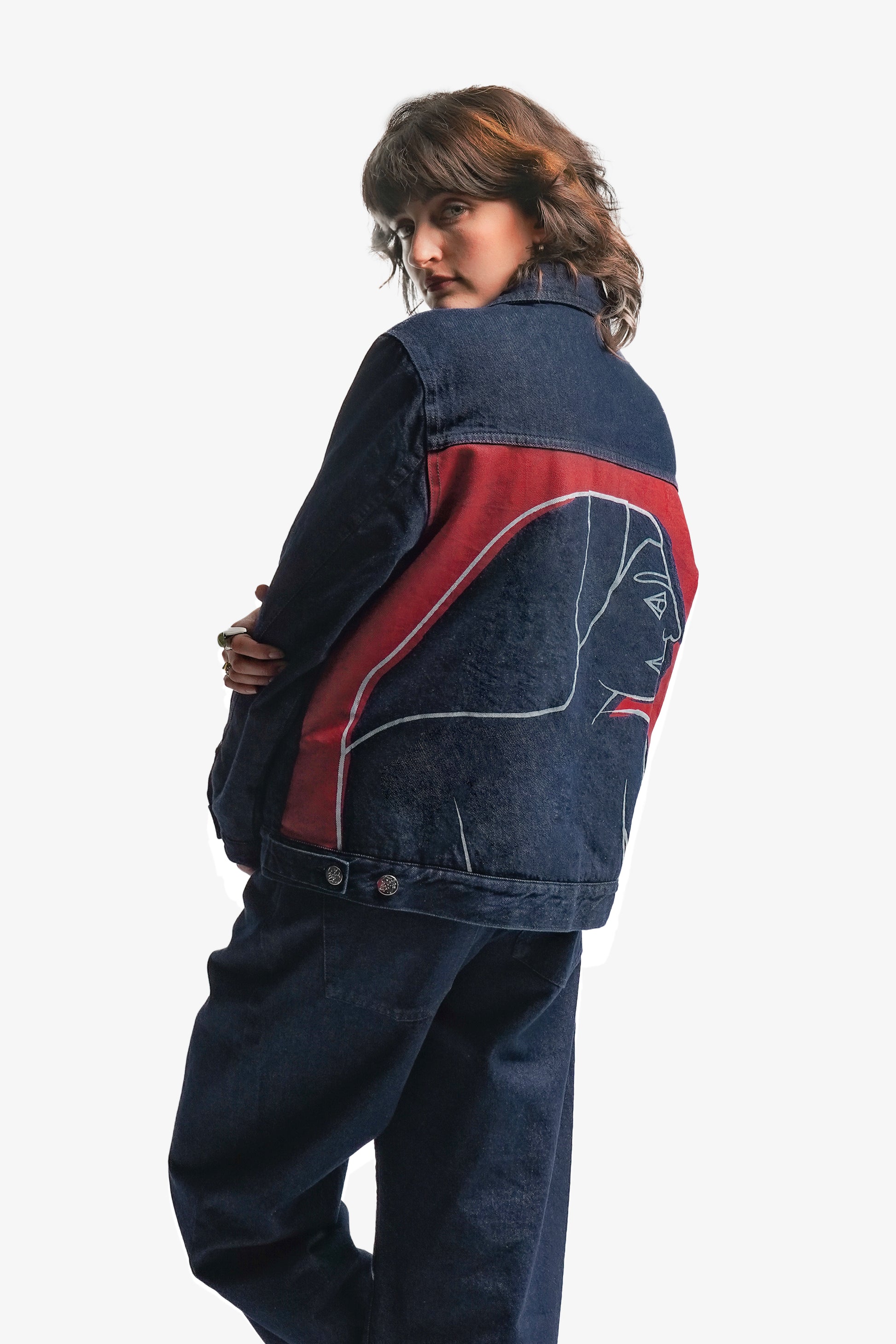Veste en denim brut doublée en sherpa, alliant robustesse et confort. Ornée d’impressions sérigraphiques sur la poitrine et le dos, ses aplats rouges et lignes blanches s’inspirent directement de la fresque Avec Vous. Le denim bleu indigo 100% coton est sublimé par des surpiqûres ton sur ton, offrant un équilibre parfait entre design artistique et finition soignée. Vêtements de créateur. Veste Original.