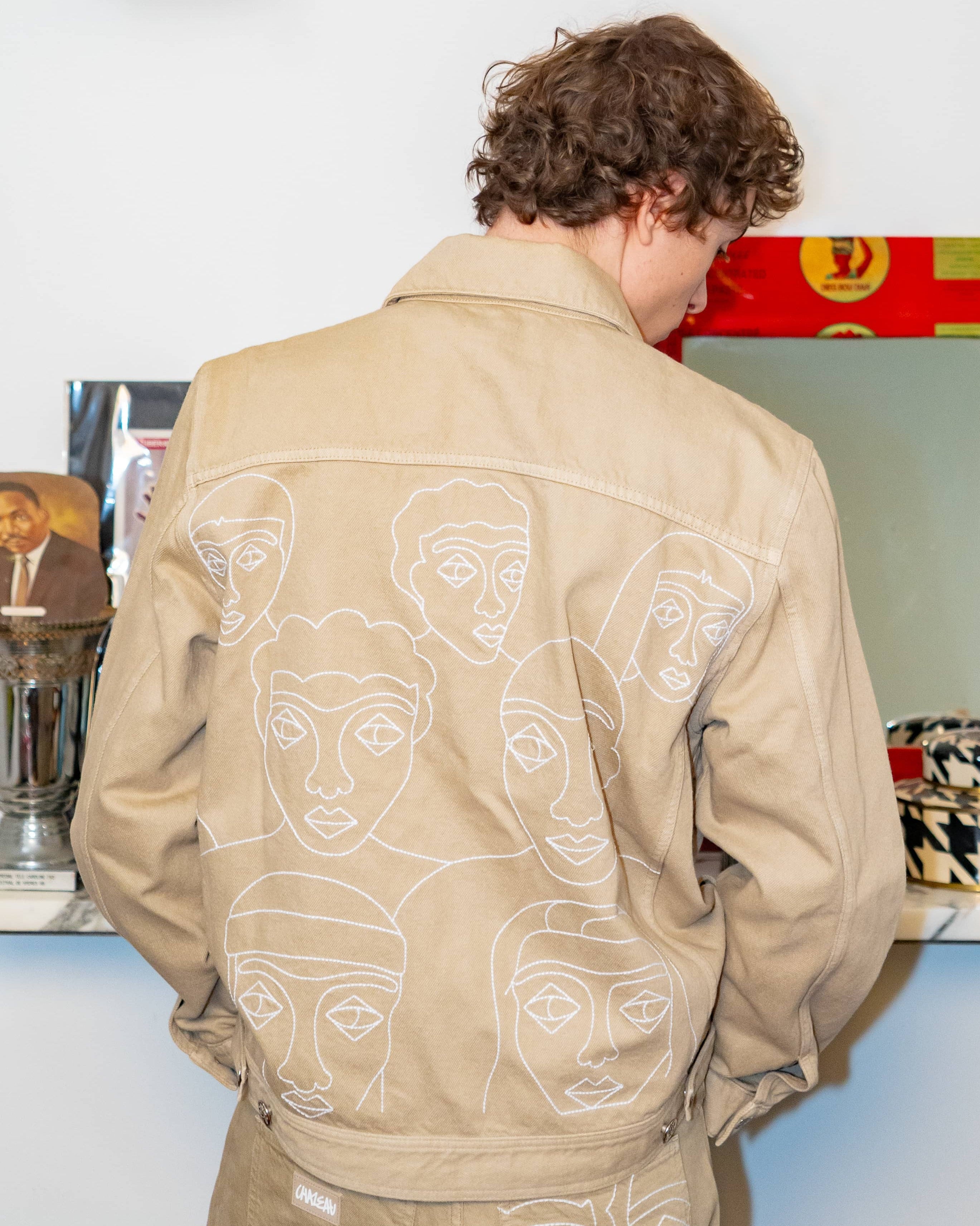 Veste trucker en gabardine 100% coton, broderies aux multiples visages représentant la fresque de la collection "Autrui"