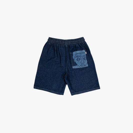Short large avec dessin au laser en plein sur le devant et la poche plaquée dos, droite au porté. Taille élastiquée. Denim deep indigo rinse, 100% coton. Surpiqûres gros fil ton sur ton.