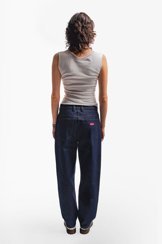 Jean brut confort en denim 100% coton, orné de sérigraphies placées sur trois poches carrées plaquées. Les aplats rouges et lignes blanches reprennent les codes graphiques de la fresque Avec Vous. Finitions avec surpiqûres ton sur ton, bouton embossé et gomme personnalisée.